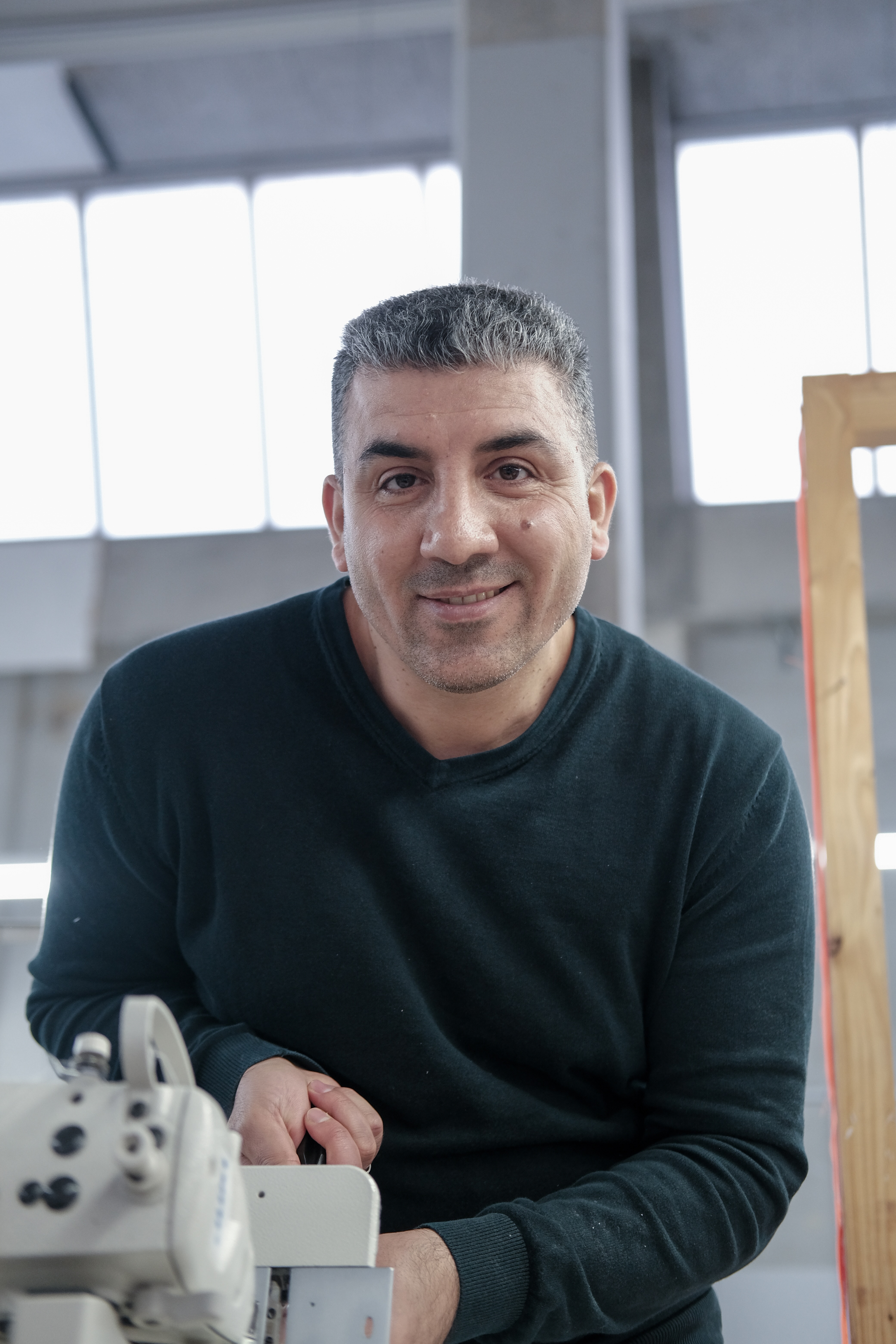 Fayiz an der Nähmaschine in der manomama-Werkstatt Augsburg