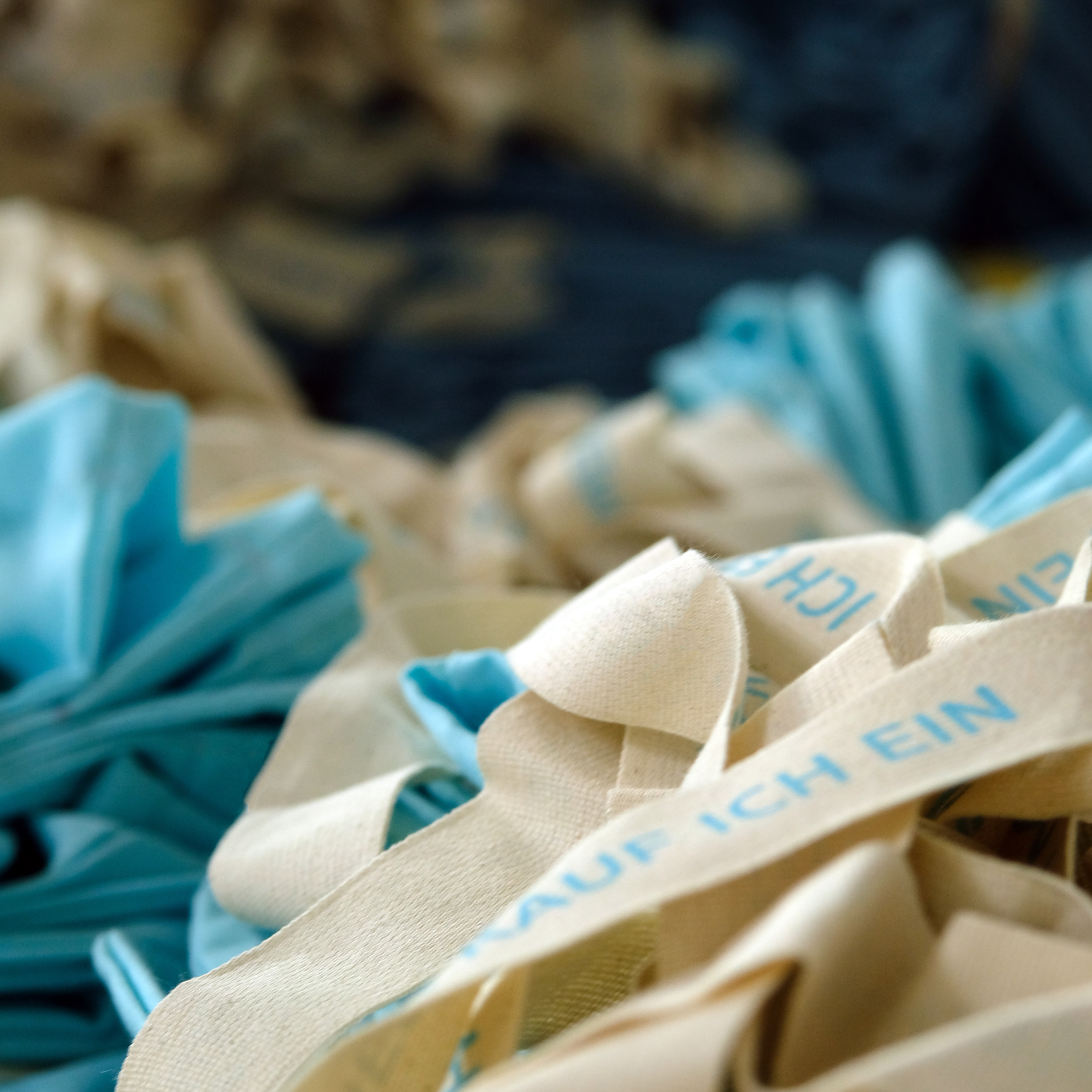 Baumwoll-Einkaufstaschen mit blauem Aufdruck in der Produktion – manomama Augsburg