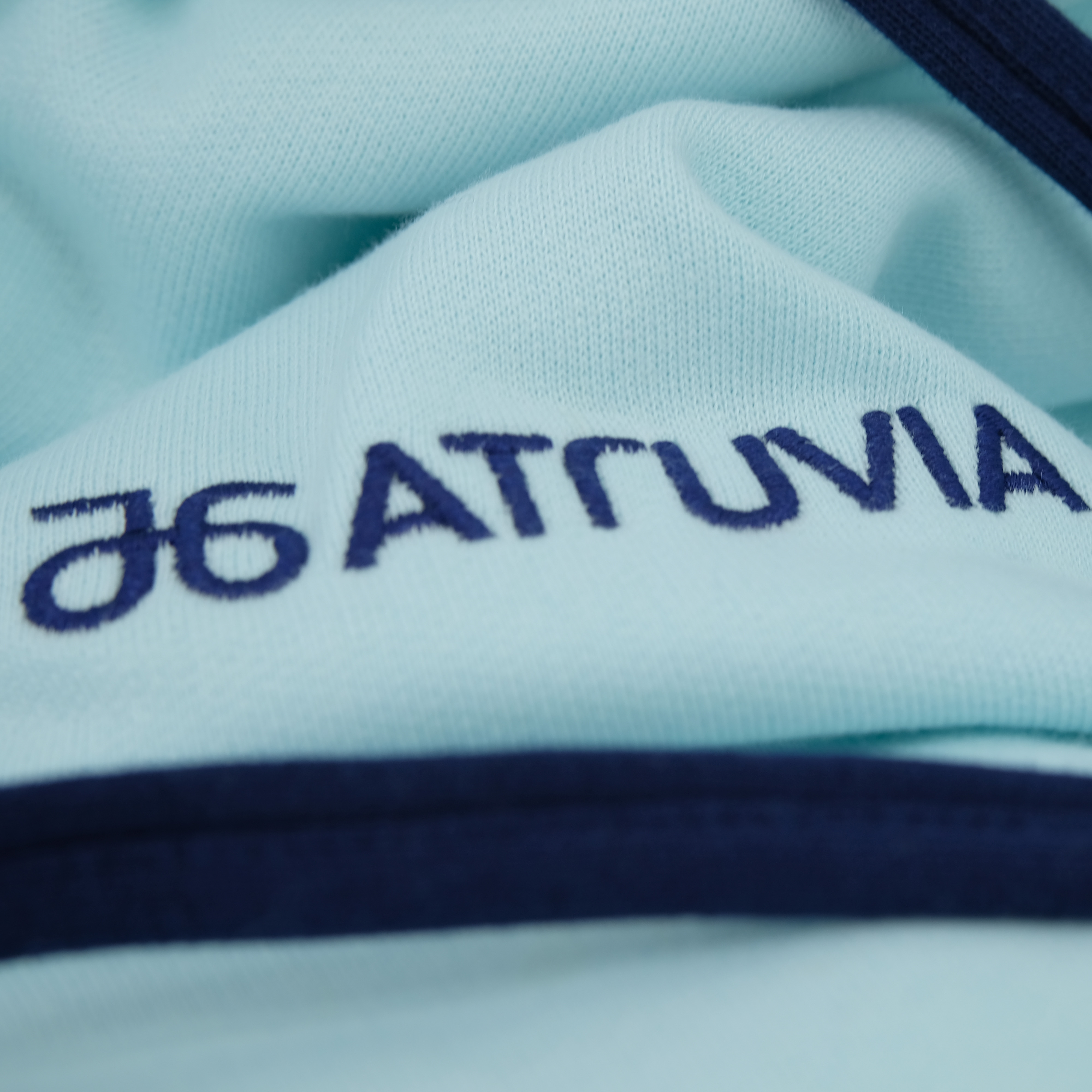 Gestickter Atruvia-Schriftzug in Navy auf hellblauem Textil – manomama Augsburg